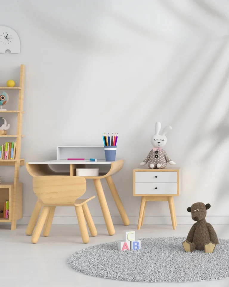 اتاق کودک مدرن مینیمال با میز چوبی، صندلی چوبی، عروسک سفید با پاپیون صورتی و فرش خاکستری با حروف ABC